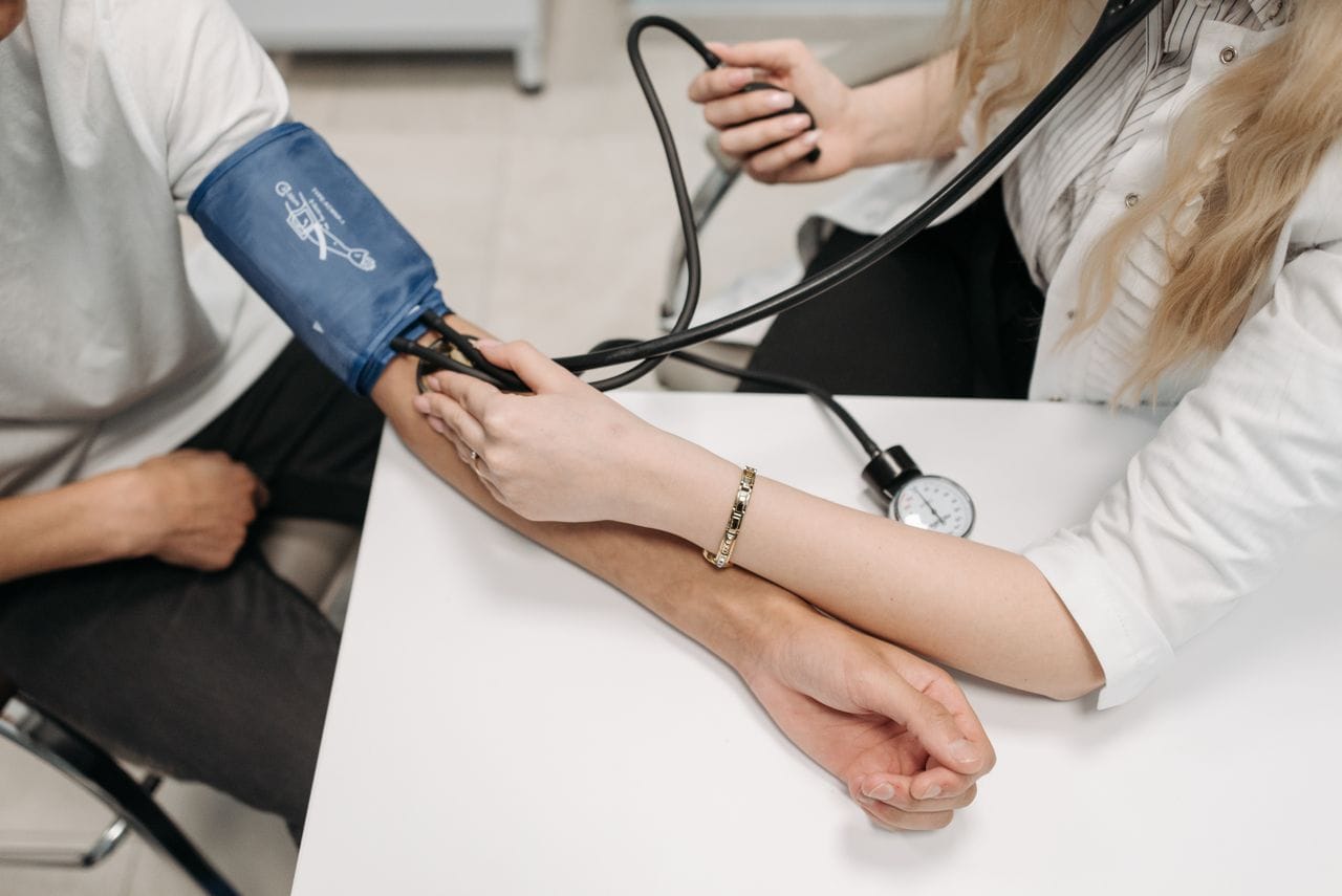 Woman having her blood pressure checked by a doctor